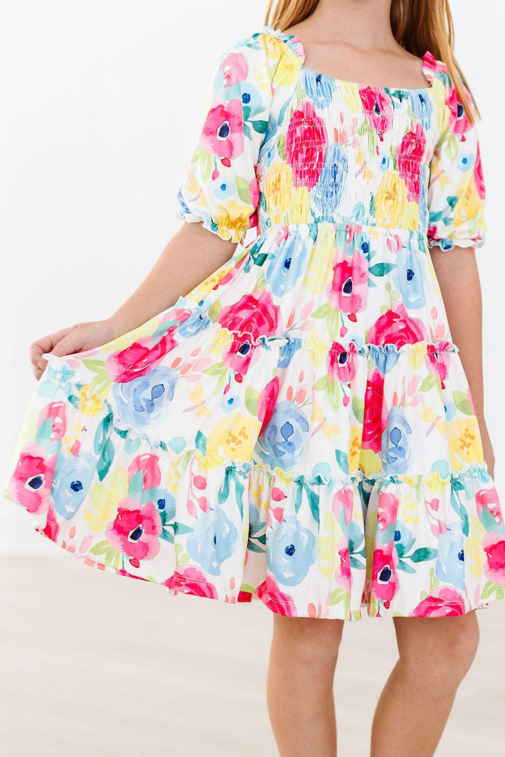 Colorful Rosie Floral Smocked Ruffle Dress for Girls, showcasing a vibrant floral pattern with a twirling skirt, perfect for play and special occasions.
