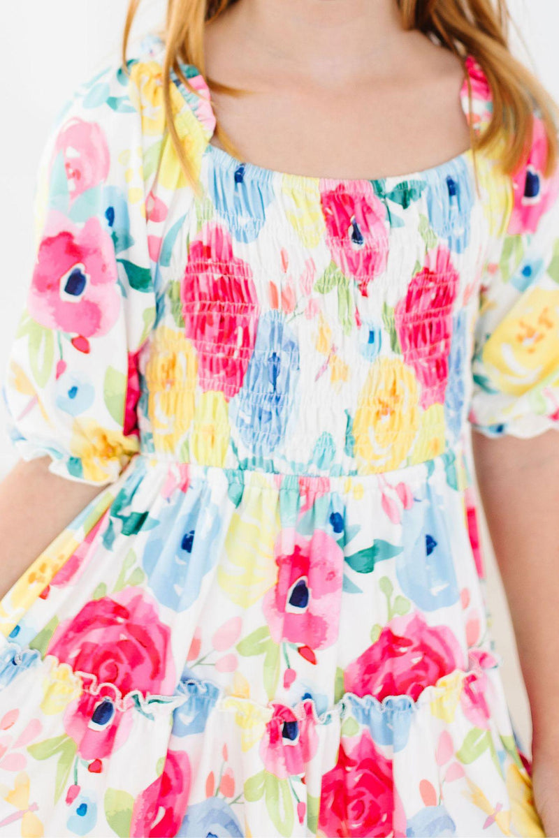 Close-up of the Colorful Rosie Floral Smocked Ruffle Dress for Girls, highlighting the beautiful smocked bodice and colorful floral patterns, perfect for stylish young wearers.