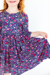 Girl wearing Flower Farm 3/4 Sleeve Pocket Twirl Dress in navy floral print with a full twirl skirt.