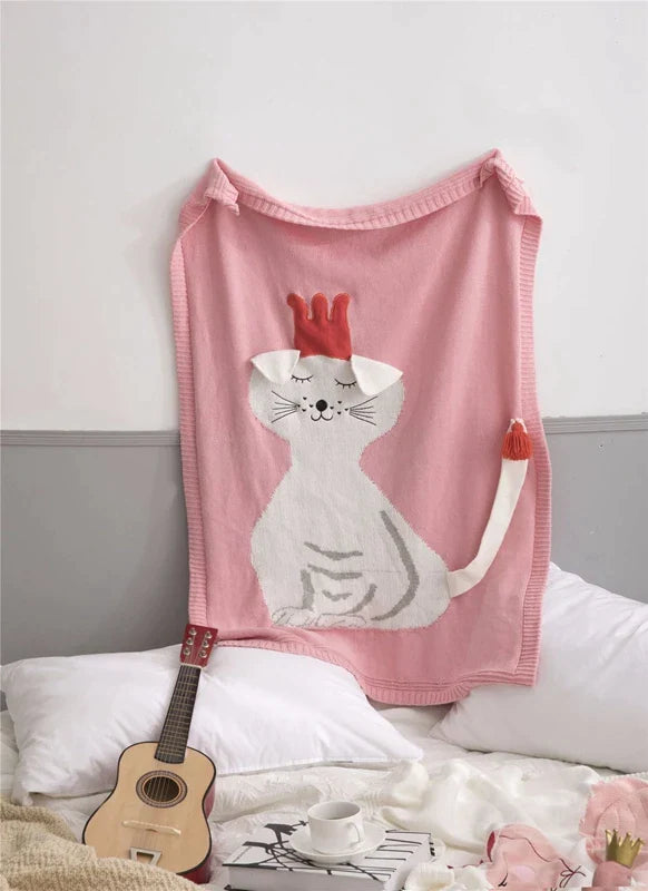 A playful pink cat blanket hanging on a wall, an example of the 'Sleepy Tight' cute animal blankets for children.