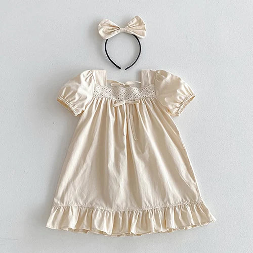 Vintage Outfits showcasing an elegant cream dress with ruffle hem and a matching bow headband for a charming look.