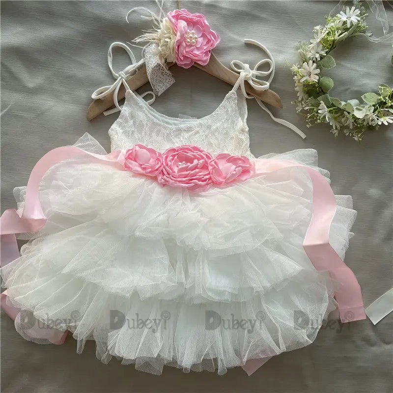 Cecilia tiered tulle dress with pink floral belt, lace bodice, pastel layers on hanger