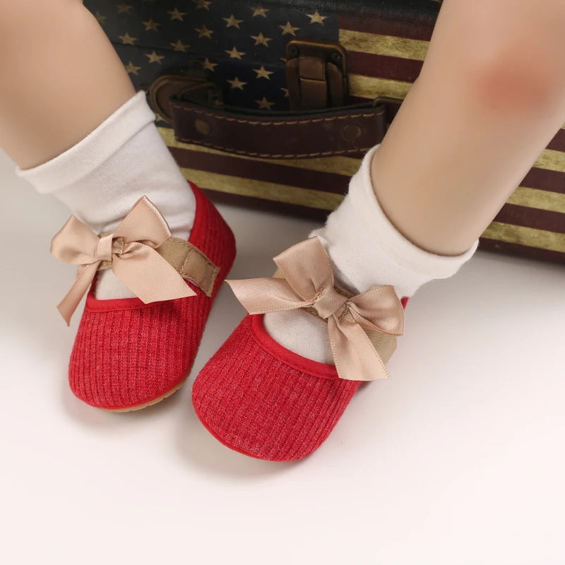 Baby Jane Satin Bow Baby Shoes in red, being worn by a baby, perfect for any fashionable outing.