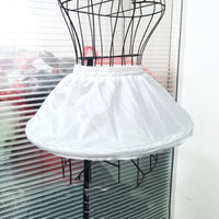 Girl's adjustable off-white short crinoline petticoat underskirt with elastic waistband on a dress form.