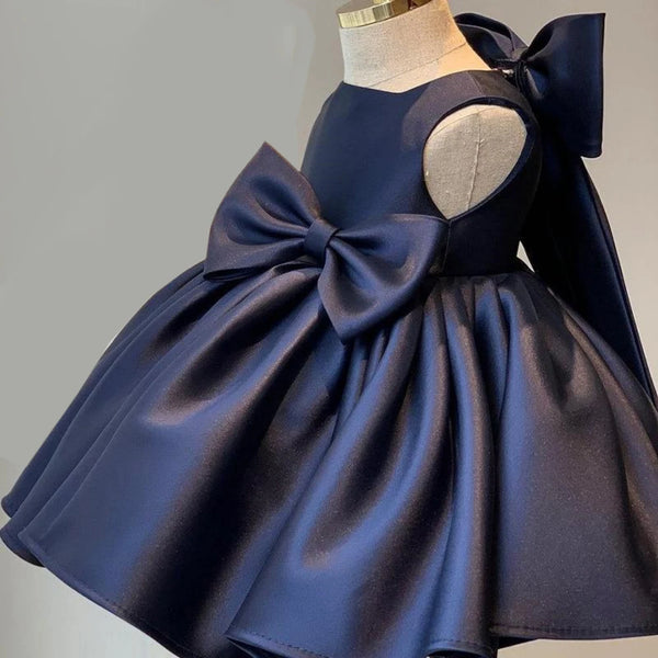 Navy blue dress with a large bow on a mannequin against a gray background