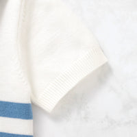 Close-up of a white towel with blue stripes on a light gray background