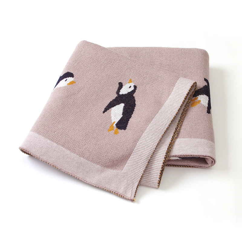 Little Penguins Children's Knit Blanket elegantly folded, showcasing adorable penguin designs - a cozy choice for any child.