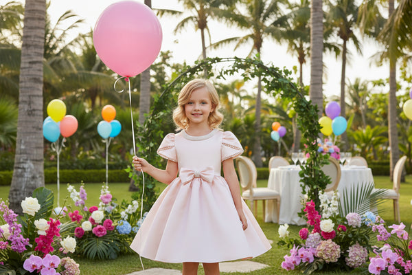Pink dress on a mannequin with a decorative mirror and flowers in the background