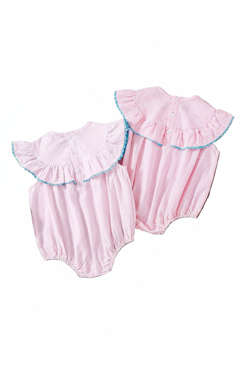 Two pink smocked seersucker birthday girl bubble rompers with ruffled neckline and blue trim.