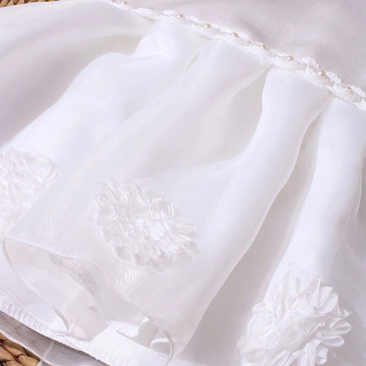 Lara Elegant Infant Dress in white with neckline, oversized bow, V-back beaded accents, tulle overskirt and headband