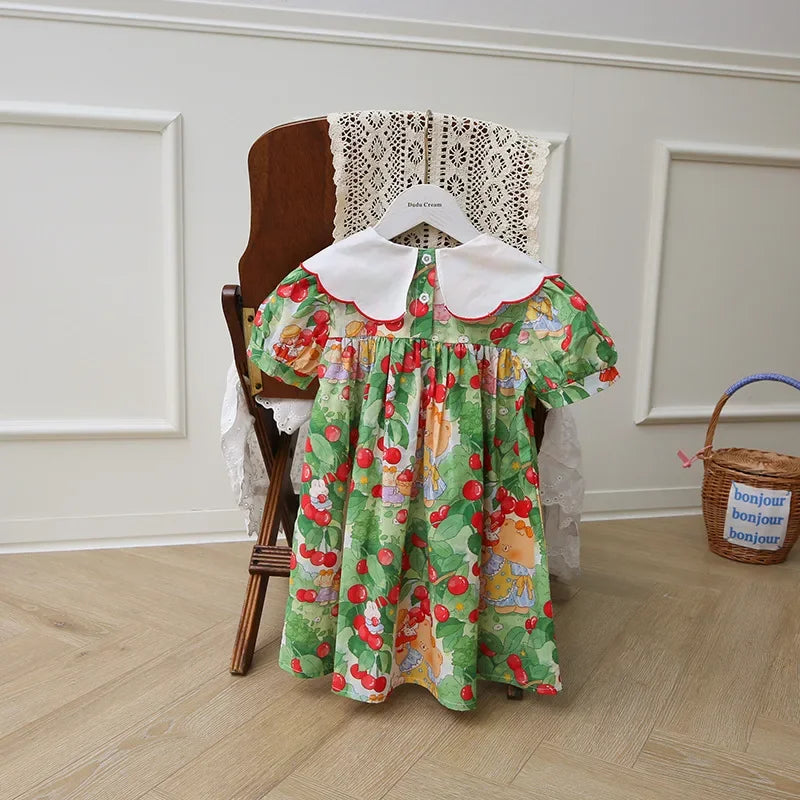 Back view of A Very Cherry Day Embroidered Dress hanging elegantly, featuring the charming cherry print dress design perfect for little girls.