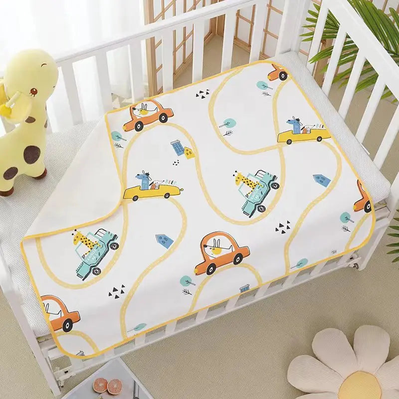 Waterproof baby changing pad cover with yellow cars and winding road print on a white crib mattress.