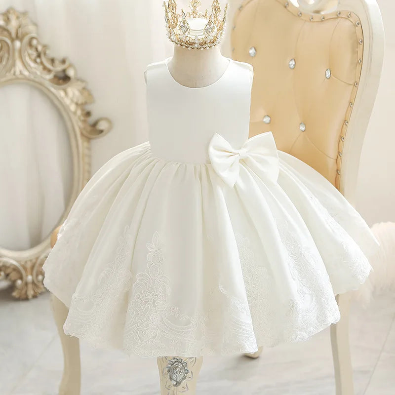 Elegant 'Monica Marie' Girls Party Dress in white, showcasing a classic round neckline, sleeveless style, and a full skirt with delicate lace embellishments.