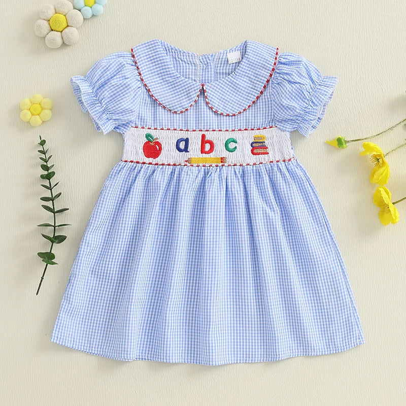 A close-up of the ABCs Embroidered Girls Dress - Peter Pan Collar, emphasizing the charming embroidery and the classic Peter Pan collar design.