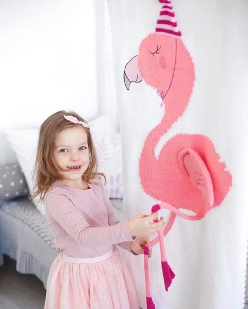 A child interacting with a pink flamingo blanket from the 'Sleepy Tight' collection, featuring cute animal blankets for kids.
