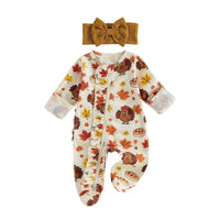 Autumn-themed baby footed romper with turkey and leaf print, front zipper, ruffled trim, and matching mustard head bow.