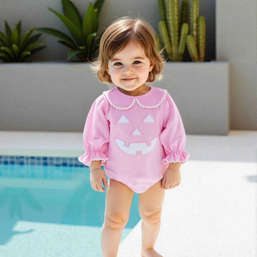 Pumpkin Polly Adorable Halloween Baby Outfit in Princess Pink on a toddler girl enjoying a sunny day by the pool, perfect for Halloween celebrations.