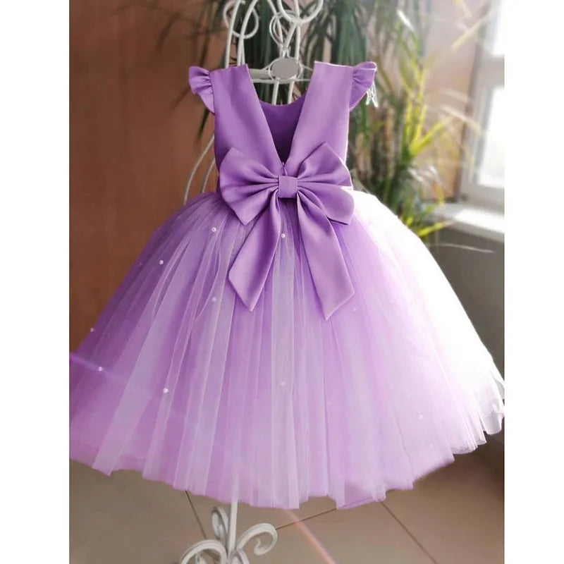 A front view of a white 'Chantelle-Elise' V-Back Occasion Dress, featuring a big bow and soft tulle, perfect for special occasions.