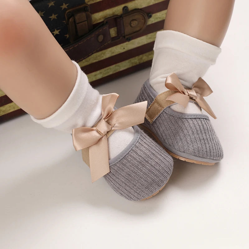 Baby Jane Satin Bow Baby Shoes in gray, worn by a baby, showing off their stylish design and comfort.