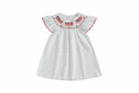 White dress with red and blue details on a beige background