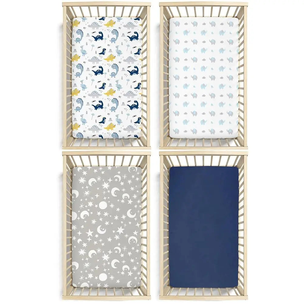 Four microfiber crib sheets for babies: dinosaur print, pale blue pattern, gray moon-and-stars, navy solid, 52x28 in.