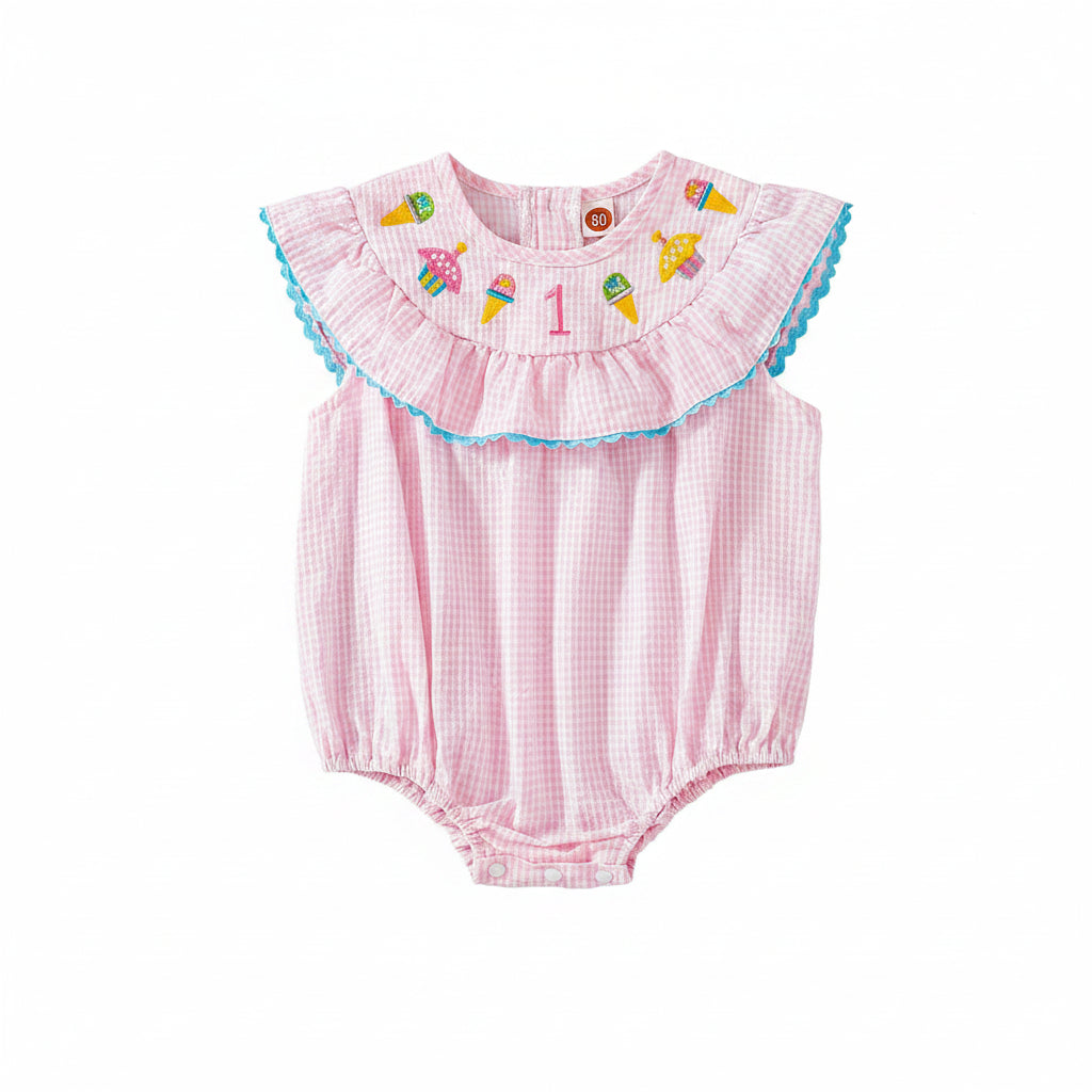 Pink check baby bubble romper with blue trim, smocked birthday motifs on yoke, ruffled collar, snap legs.