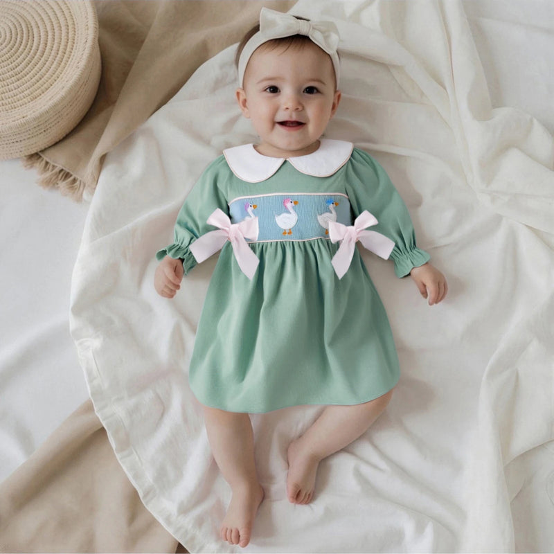 Cute infant wearing the 'Goosey Goose' Goose Embroidered Mint Smocked Long-Sleeve Dress, featuring an adorable Peter Pan collar and playful goose embroidery.