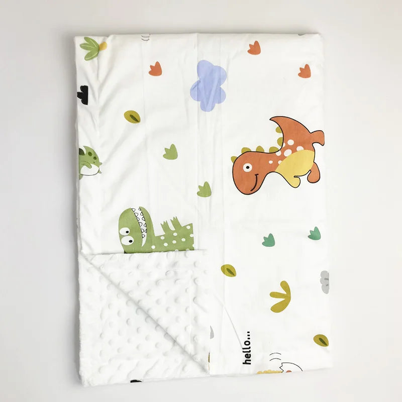 White minky baby blanket featuring cute dinosaur and cloud prints with soft dotted texture, ideal gift for toddlers.