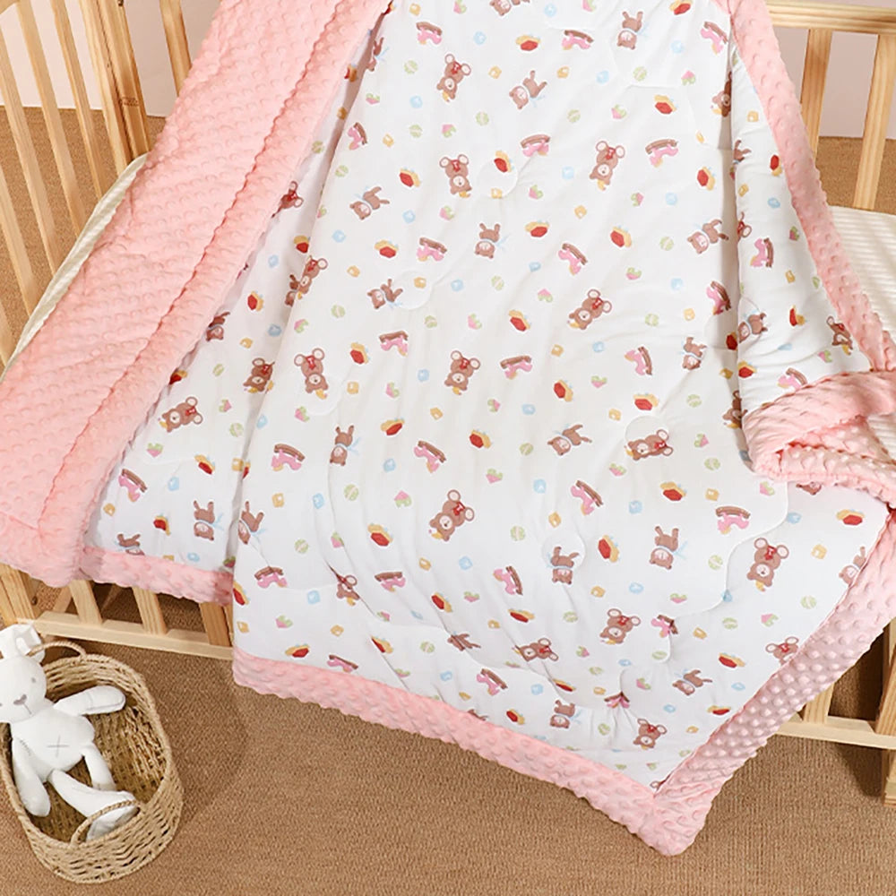 Quilted 120 x 150 cm kindergarten nap blanket with raised dots on pink border and white bear-print side.
