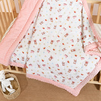Quilted 120 x 150 cm kindergarten nap blanket with raised dots on pink border and white bear-print side.