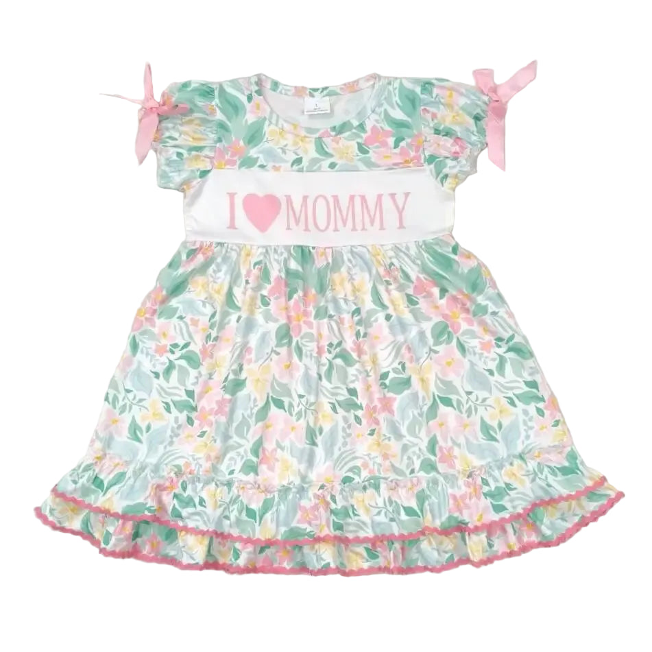 I Love Mommy frilly floral dress with embroidered text, pastel garden print, pink satin bows, and ruffled hem.