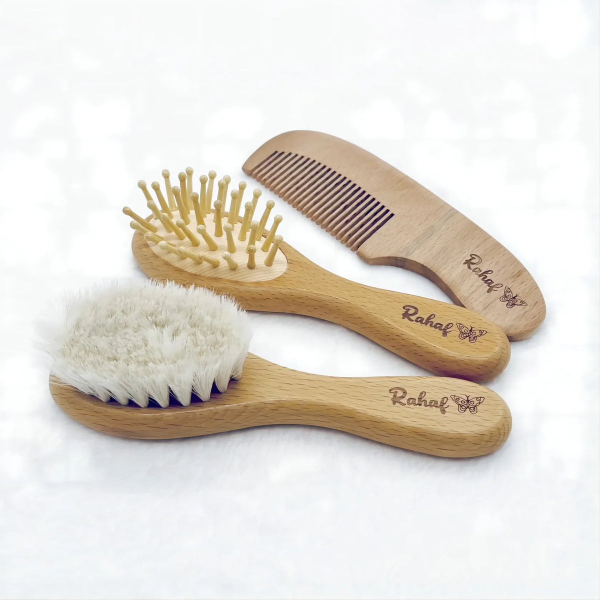 Set of three personalized wooden baby brushes and combs with engraved name.