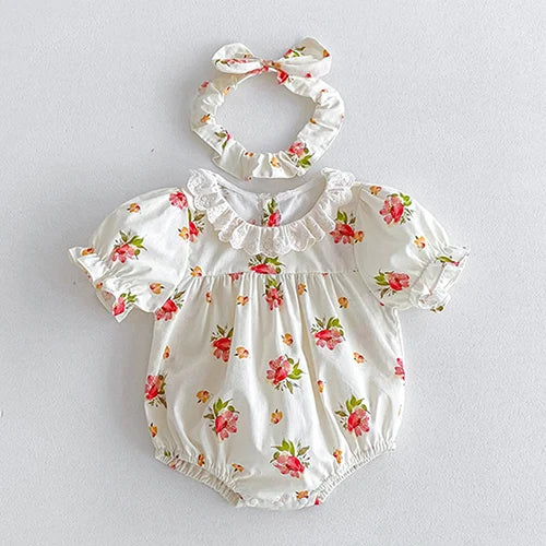 Vintage Outfits for babies showcasing a white floral romper with puff sleeves and a matching hair scrunchie from The Palm Beach Baby.