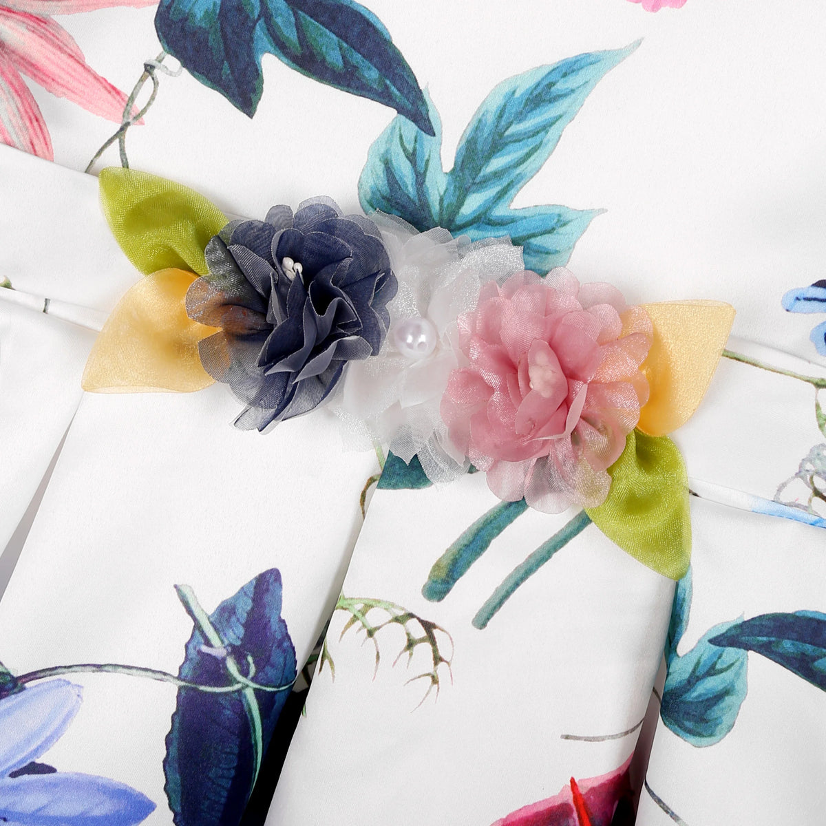 Floral headband with navy, white, and pink fabric flowers against tropical garden print fabric.