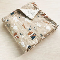 Two-sided children's minky blanket in beige with raised dot texture and rabbit and bear prints.