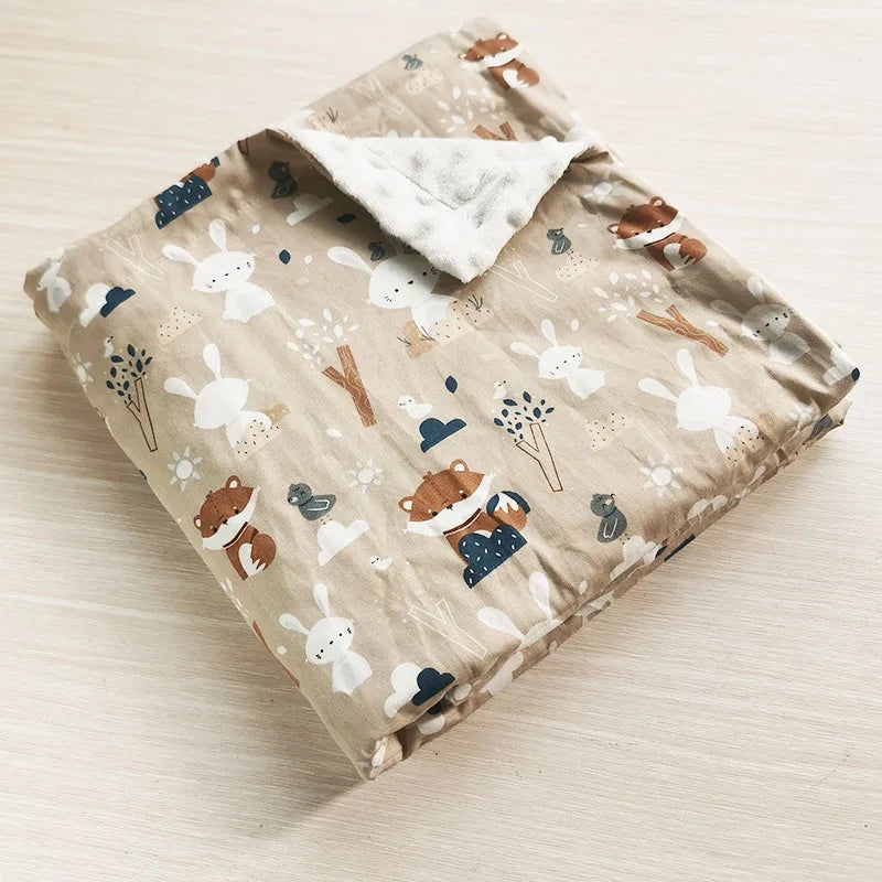 Folding baby blanket with woodland fox and rabbit print, featuring soft white minky dots on a beige background for infants and toddlers.