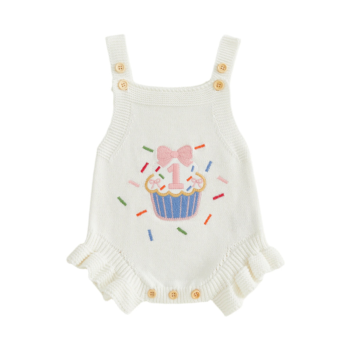 Cream knit baby romper overalls with cupcake embroidery, pink bow, colorful sprinkles, and buttoned straps.