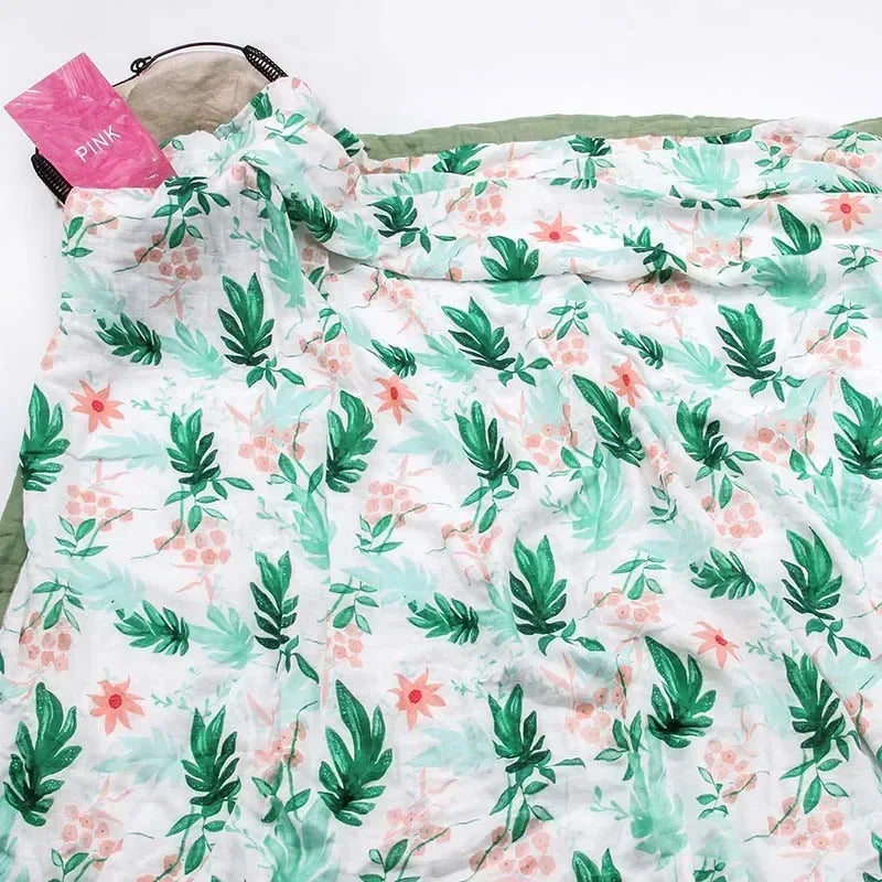 Two-layer bamboo cotton newborn swaddle blanket with green leaves and pink flowers pattern; unisex with green trim.