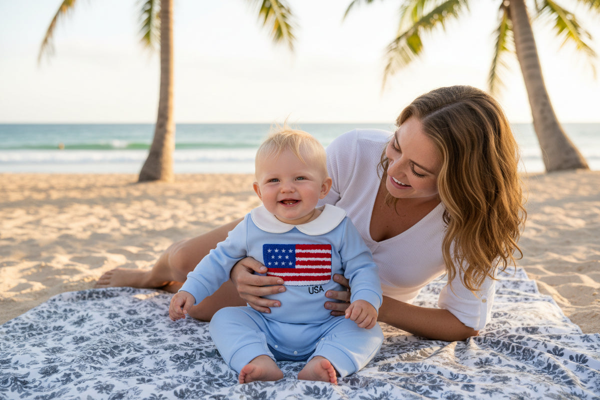 Light blue baby romper with American flag patch on a white background