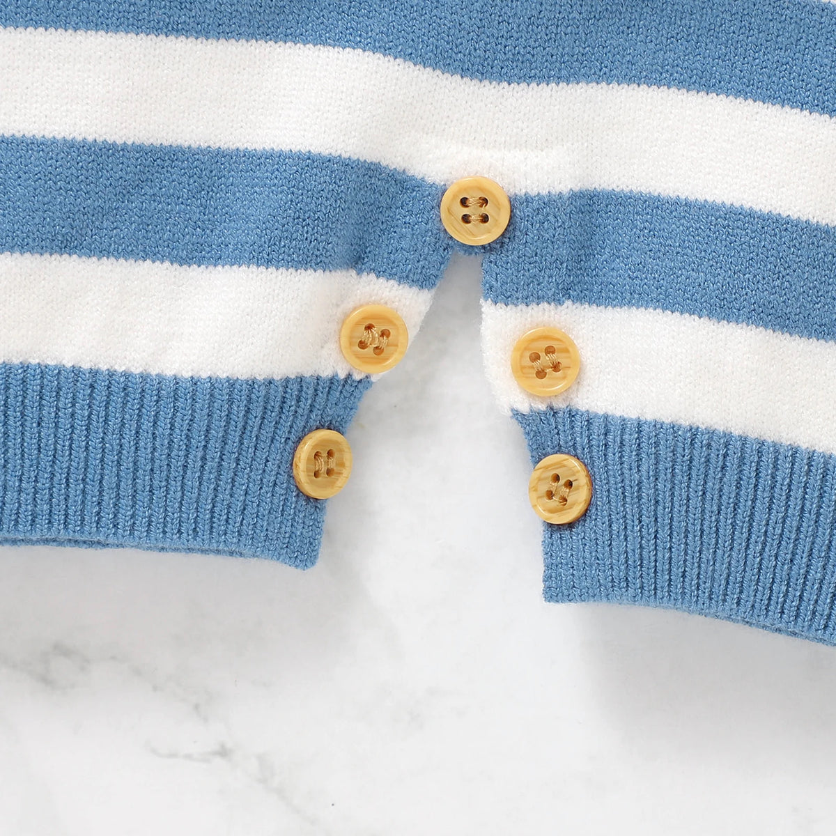 Close-up of a blue and white striped sweater with wooden buttons on a marble background