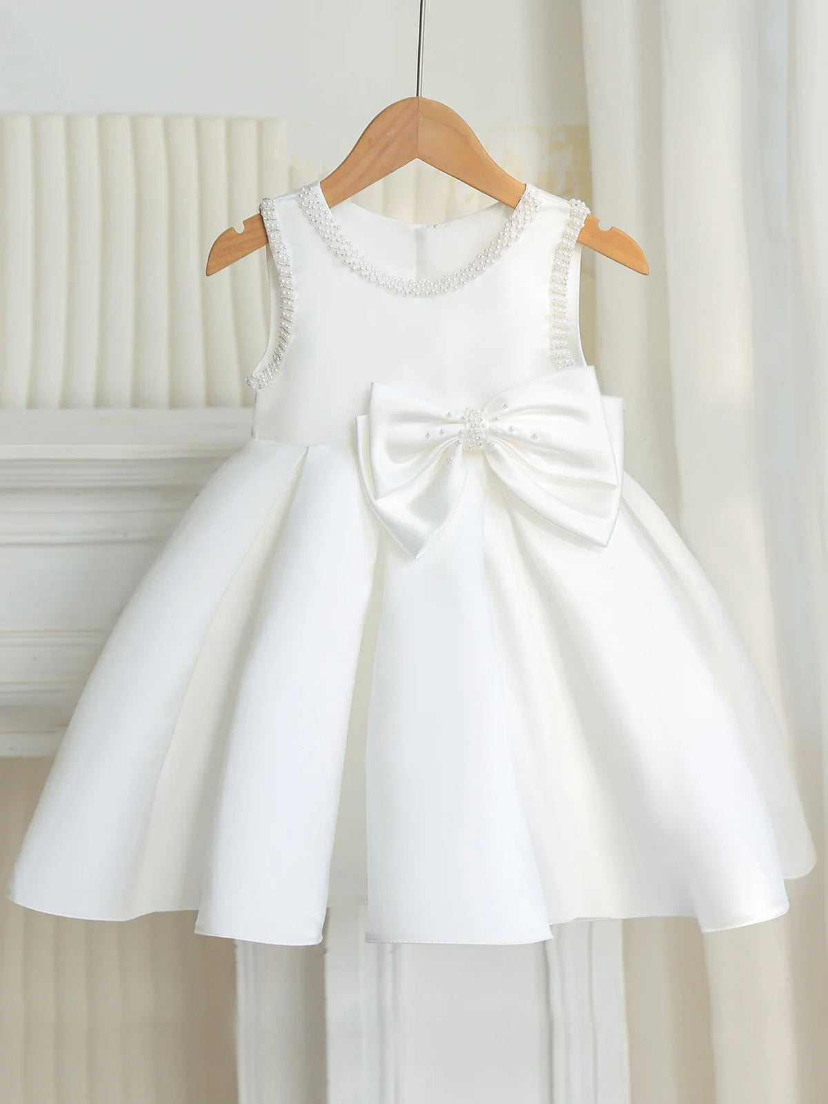 Taylor Elegant Beaded Formal Party Dress for girls ages 2–7, knee-length white gown with beaded neckline and bow.