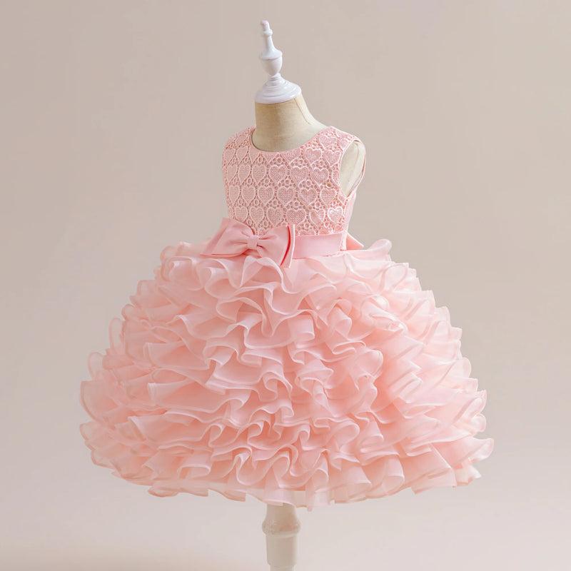 Back view of the pink 'Evengaline' Tulle Tiered Dress, highlighting the bow and ruffled design, perfect for young girls.