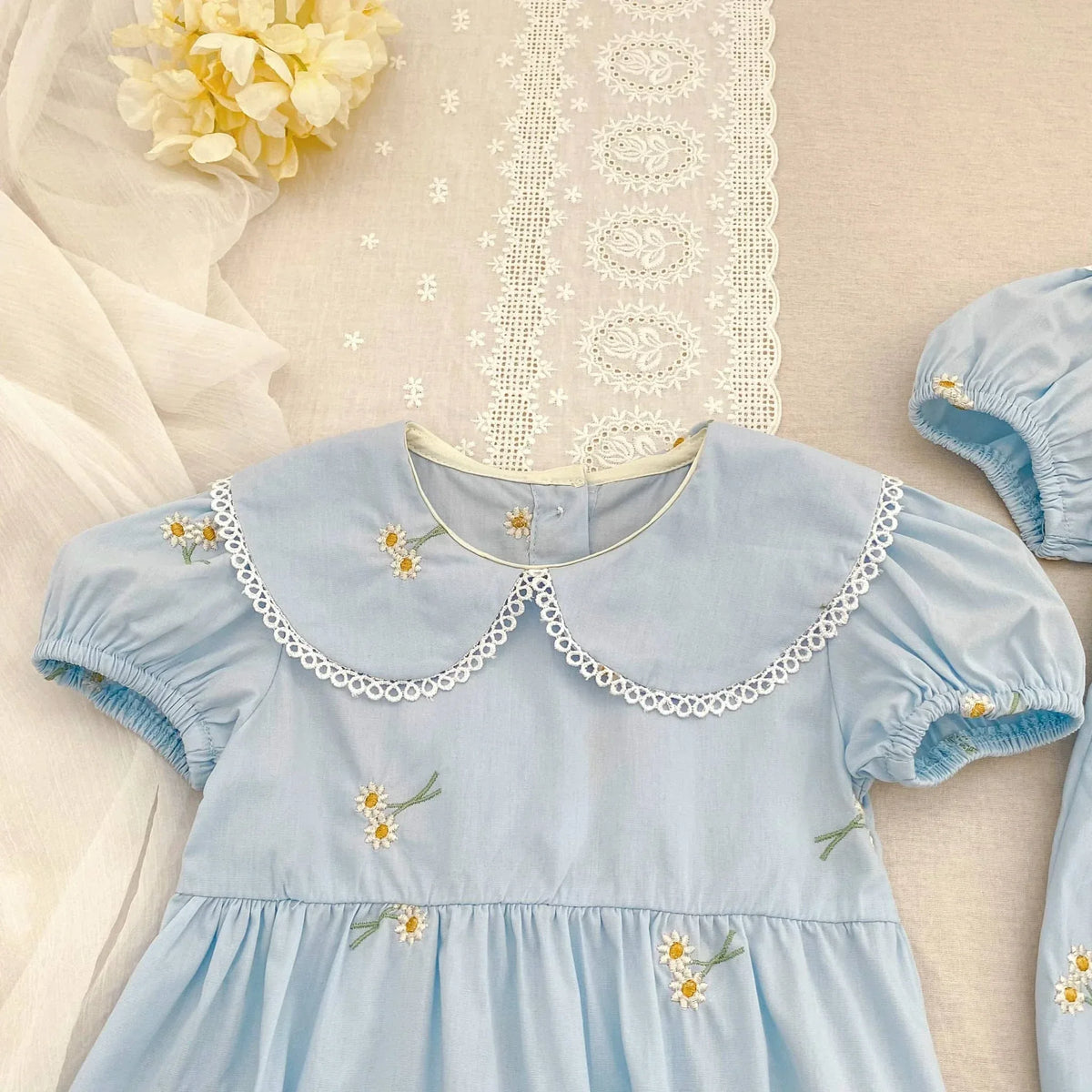 Light blue embroidered baby bubble romper with floral designs and scalloped collar for babies and kids