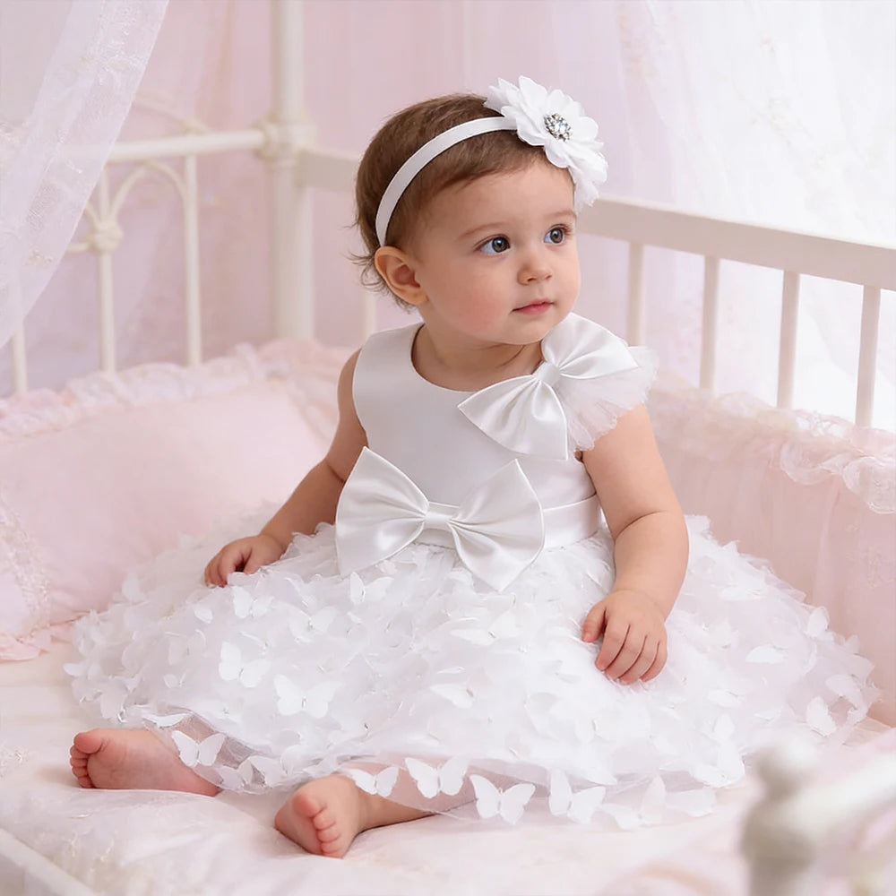 Baby girl in Butterfly Wishes Formal Dress with matching headband, white gown with butterfly appliques and satin bows.