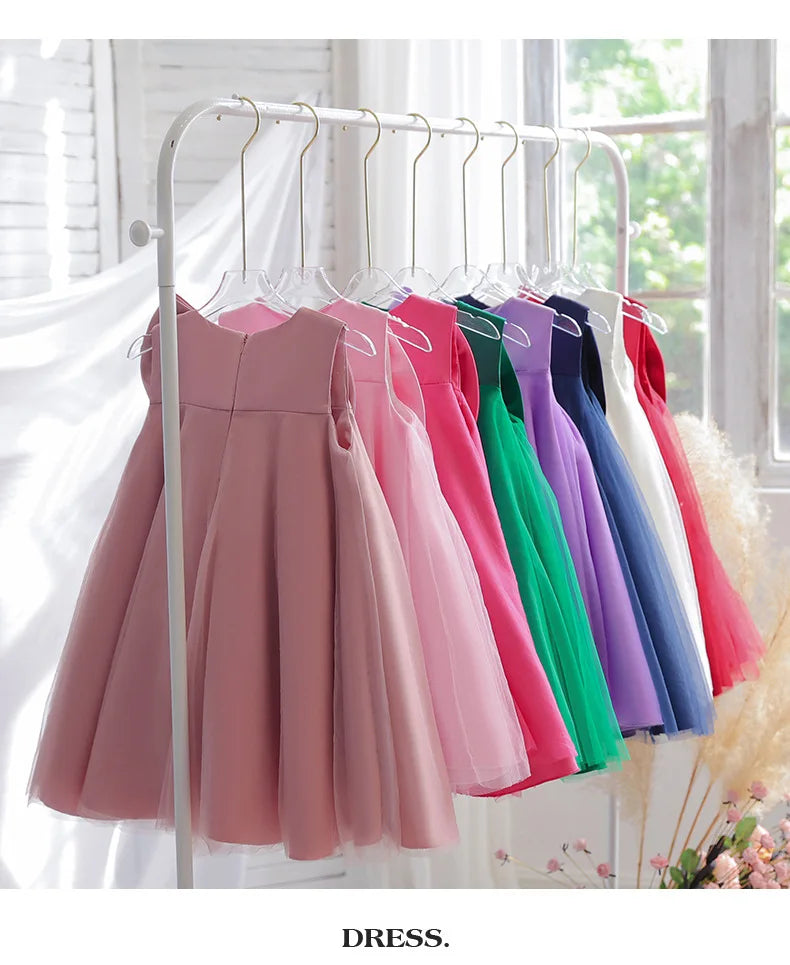 Sari-Elle Elegant Party Dress With Large Bow in 8 colors on a rack for girls aged 4–6; A-line dresses.