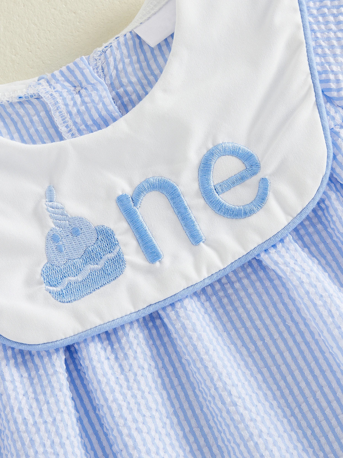 A joyful child wearing the Sweet Birthday Wishes First Birthday Romper with Embroidered Bib, making it a memorable first birthday romper.