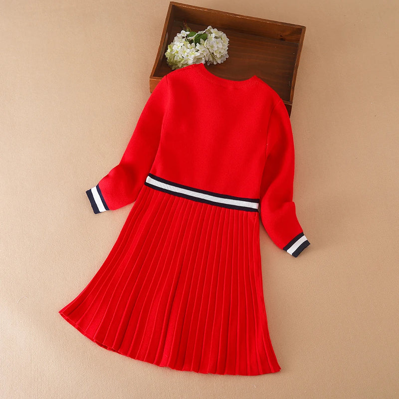 Back view of the Preppy Darla Knit Dress Long Sleeves, highlighting the pleated skirt and navy striped waistband, a chic choice for little trendsetters.
