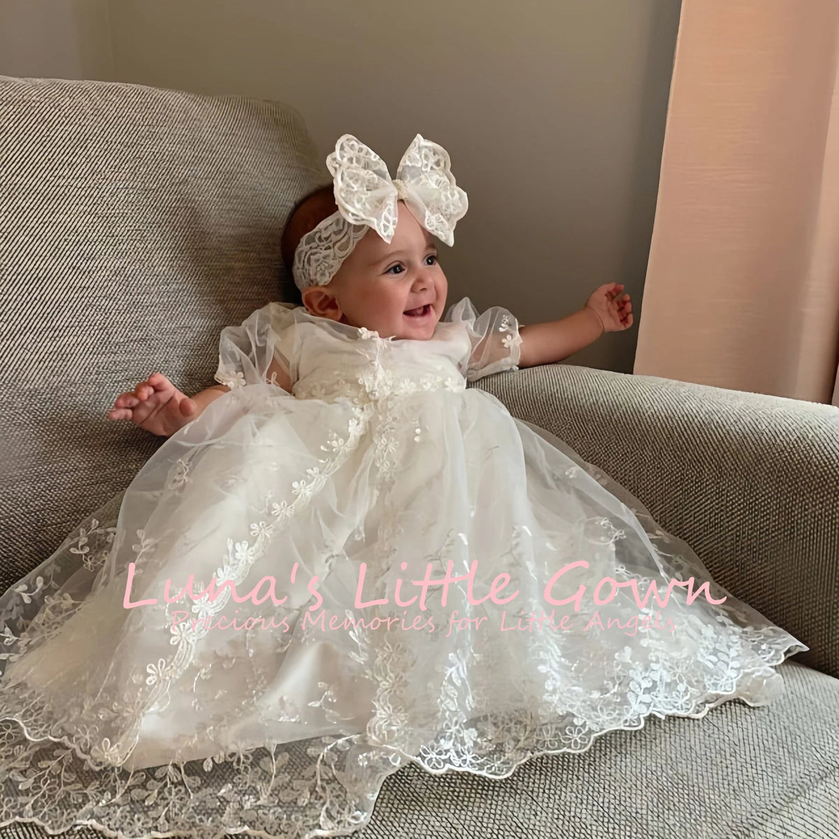 Baby girl in Mila Heirloom Lace baptism gown with embroidered flowers, lace overlay, and large lace bow headband.