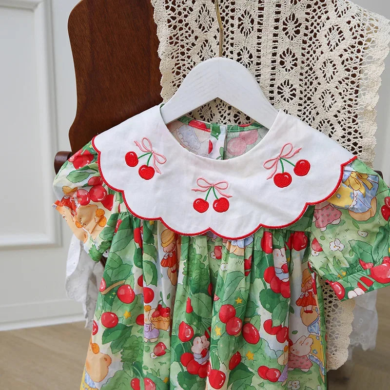 Close-up view of A Very Cherry Day Embroidered Dress, highlighting the whimsical cherry print dress with embroidered cherries on the collar.