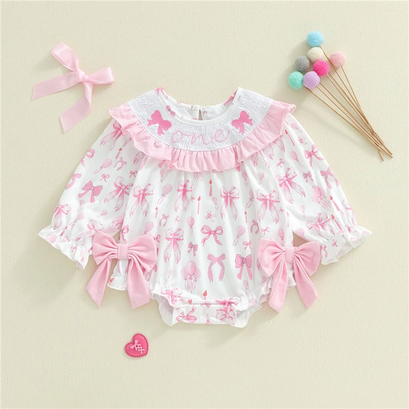 Baby romper with pink bows and ruffles on a beige background